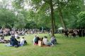 Viele Menschen sitzen auf einer Wiese