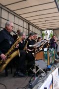 Vorne spielt ein Saxophonist, dahinter die Big Band