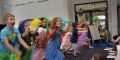 Viele Kinder laufen mit buntenTüchern durch den Raum