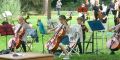 Kinder spielen Cello im Park