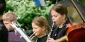 Kinder spielen auf Blasinstrumenten im Bürgerpark