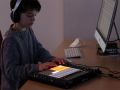 Ein Junge mit Kopfhörern spielt an einem Computer
