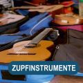 Gitarren, Gitarrenkästen und Gitarrentaschen liegen auf dem Boden